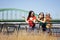 Two young best female friends standing by the old bridge