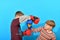 Two young boxers are fighting in boxing gloves in the studio on a blue background