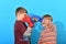 Two young boxers are fighting in boxing gloves in the studio on a blue background