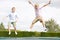 Two young boys jumping on trampoline smiling