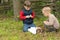 Two young boys lighting a fire outdoors