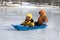 Two Young Boys Sled on Icy Lake