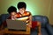 Two Young boys using a laptop computer and smiling