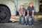 Two Young Boys Wearing Cowboy Hats Leaning Against an Antique Truck in a Rustic Country Setting