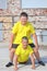 two young boys in yellow T-shirts are training. Training of abdominal muscles