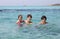 Two young brothers and their younger sister in the clean sea