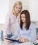 Two young business woman in the office looking at a document.