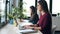 Two young business women friends working together with laptop in the office at home