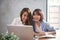 Two young business women sitting at table in cafe. Asian women using laptop and cup of coffee. Freelancer working in coffee shop.