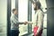 Two young businessmen shaking hands in modern office hall