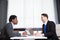 Two young businessmen, white desk, job interview, teamwork