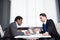 Two young businessmen, white desk, job interview, teamwork