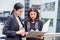 Two young businesswomen looking into document file folder for analyzing profit circulation or sale break even point after