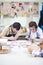 Two Young Caucasian Ceramists Painting and Glazing Clay Crafts