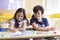 Two young caucasian children having fun doing homework together in class. Primary education