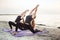 Two young caucasian females practicing yoga on beach