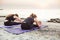 Two young caucasian females practicing yoga on beach