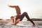 Two young caucasian females practicing yoga on beach