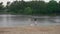 Two young caucasian girls in summer dresses play and dance in rain in pond of city park. Girls are free froom studying