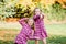 Two Young Caucasian Sisters Strike a Pose in Matching Pink Flannel Dresses