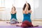 Two young caucasian woman doing gomukhasana with eagle arms