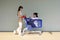 Two young Caucasian women chilling in a blue shopping cart.