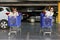 Two young Caucasian women chilling in blue shopping carts.