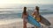 Two young Caucasian women stand by the sea with surfboards, with copy space