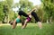 Two young Caucasian women yogi doing balance back stretch acro yoga pose. Women doing stretching workout in park outdoors at sunse