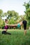 Two young Caucasian women yogi doing balance back stretch acro yoga pose. Women doing stretching workout in park outdoors at sunse