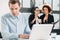 Two young cheerful female employees talking in the office