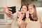 Two young cheerful females with homemade icecream making selfie in the kitchen