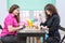 Two young cheerful women playing chess together