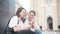 Two young cheerful women taking a selfie with a smartphone in a city center