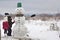 Two young children, boy and girl, finish doing smiling snowman i