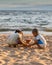 Two Young Children Building a Sandcastle on a Beach in Thailand