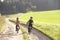 Two young children ride bicycles in park