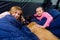 Two young children in a tent with sleeping bags