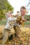 Two Young Children Throwing Fall Leaves Outside