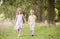 Two young children walking on path holding hands