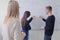 Two young college male and female students with young female teacher writting on the chalkboard during a math class. Resolving