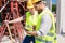 Two young construction workers smiling while using a tablet duri