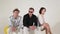 Two young cute males and pretty mature female are sitting on big balls in studio