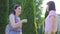 Two young deaf-mute women communicate using sign language in the park close up