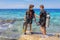 Two young divers check diving equipment in sea