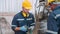 Two young engineer man examining and measuring steel together with expertise at lathe factory.