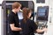 Two Young Engineers Operating CNC Machinery On Factory Floor