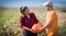 Two young farmers harvesting giant pumpkins at field - Thanksgiving and Halloween preparation