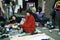 A two young fashionable girls friend sells their old things, sitting on the pavement in Bricklane at a Sunday street flea market