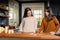 Two young femaies llooking at deck of tarot cards in a kitchen